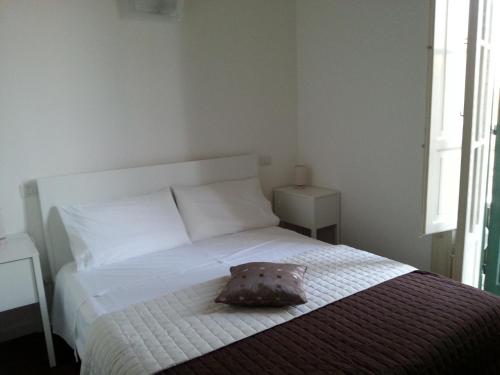 a bedroom with a white bed with a pillow on it at Ai Lattarini House in Palermo