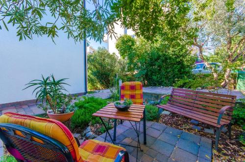 a patio with a table and chairs and a bench at Apartment Tihana in Stari Grad