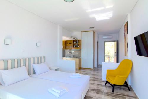 a living room with a white couch and a yellow chair at Belvedere Suites Korfos in Korfos