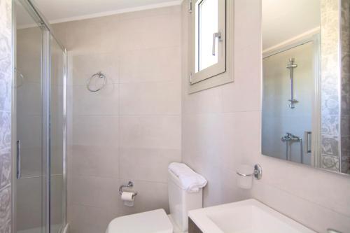 y baño con aseo, lavabo y ducha. en Belvedere Suites Korfos, en Korfos