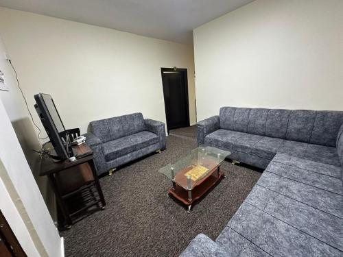 a living room with two couches and a tv at Sultan Palace Apartments in Wadi Musa