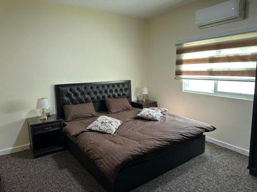 a bedroom with a large bed with two pillows on it at Sultan Palace Apartments in Wadi Musa