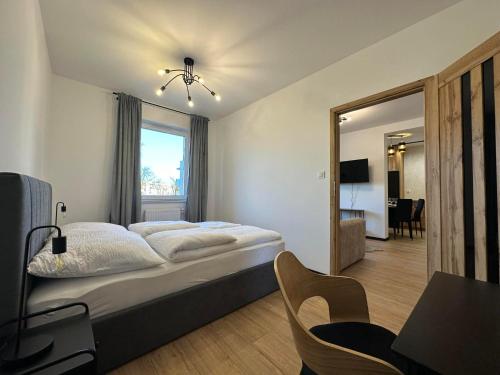 a bedroom with a bed and a desk and a window at Apartament w centrum 5A in Iława