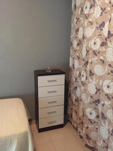 a bedroom with a bed and a dresser with a curtain at Medina Azahara in El Higuerón