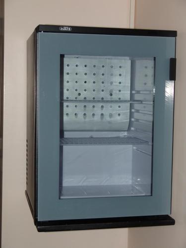 an empty refrigerator with its door open on a wall at Hotel Cosmos in Athens