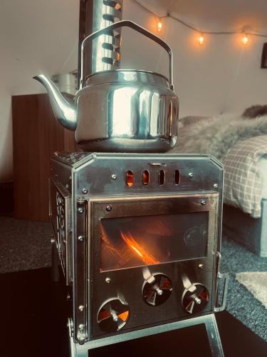 a stove with a pot on top of it at Torshaug glamping in Trondheim