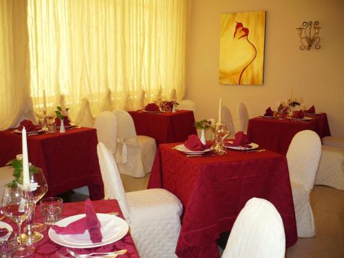 a dining room with red and white tables and chairs at Semiramide Palace Hotel in Castellana Grotte