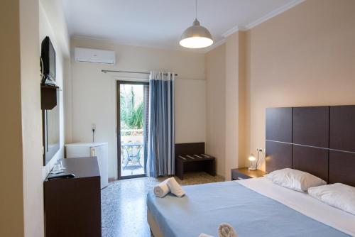 a hotel room with a bed and a window at Kamari Blue Boutique Hotel in Kamari