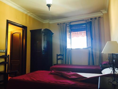 - une chambre avec 2 lits et une fenêtre dans l'établissement Hostal Pechi, à Huévar