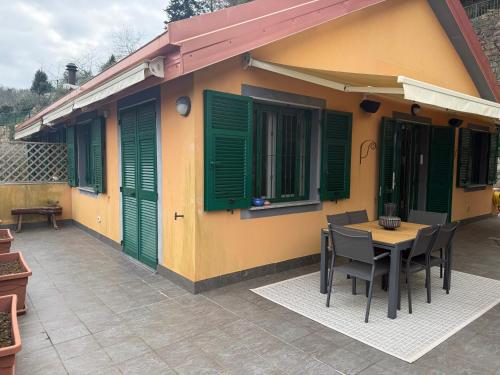 a house with green shutters and a table and chairs at Villa Goga in Ruta