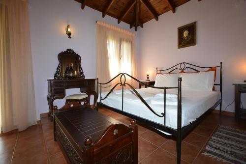 a bedroom with a bed and a chair and a window at Guesthouse Rodamos in Taxiarchis