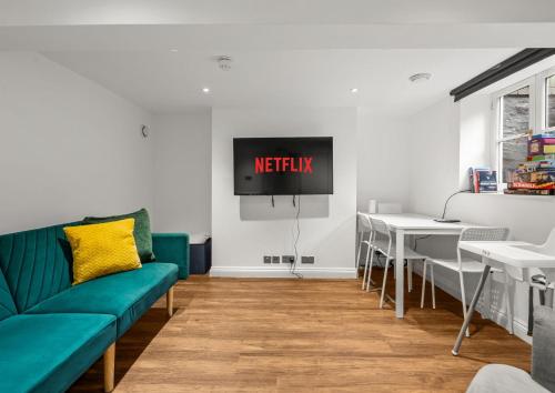 a living room with a couch and a tv on the wall at 6 BR 4 Bath Central Worcester Sleeps 12 in Worcester