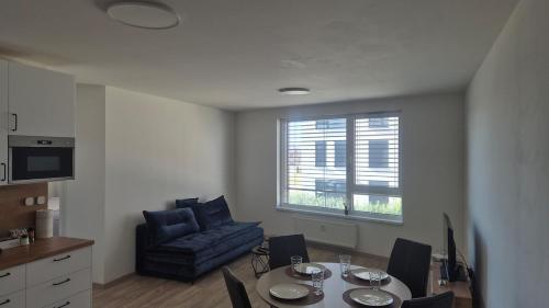 a living room with a table and a blue chair at 3-room apartment in Trnava