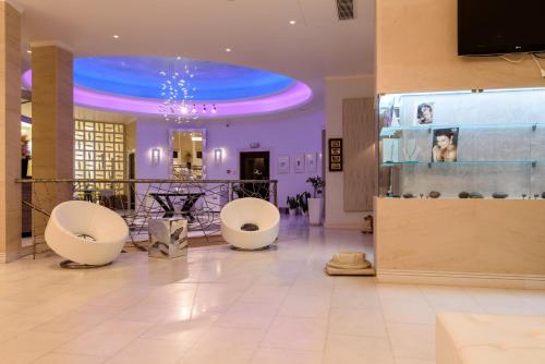 a lobby with two white chairs and a blue ceiling at La Mer Deluxe Hotel & Spa in Kamari