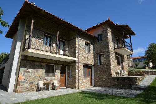 an exterior view of a stone house with a balcony at Guesthouse Rodamos in Taxiarchis