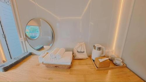 a bathroom with a mirror and towels on a wooden floor at Hotelru Koh Larn-โฮเต็ลรุ เกาะล้าน in Ko Lan