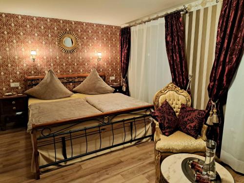 a bedroom with a bed and a chair and a mirror at Héritage B&B in Mülheim an der Mosel
