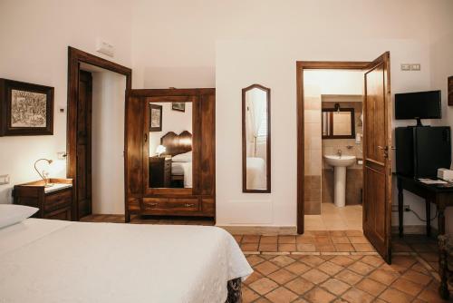 a bedroom with a bed and a bathroom with a sink at Il Casino di Remartello in Loreto Aprutino
