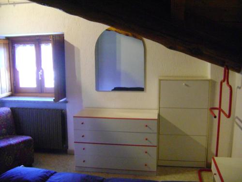a bedroom with a dresser with a tv on the wall at La Maison Nouva 1977 in Aosta