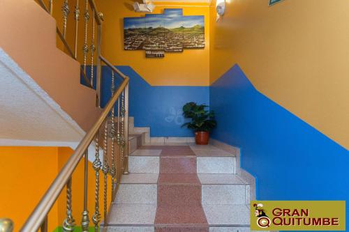 a stairway with a blue and orange wall at Hotel Gran Quitumbe in Quito