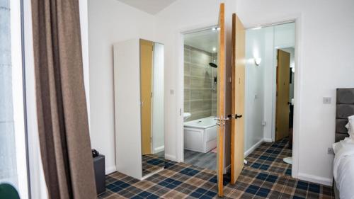 a room with a bathroom with a tub and a toilet at The Way House in Manchester