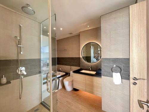 a bathroom with a shower and a sink and a mirror at Terra Bay Homestay in Ha Long