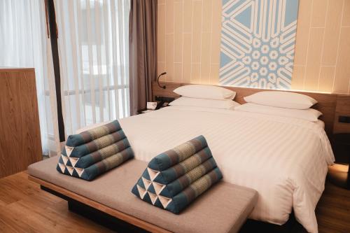 a bedroom with a large bed with two pillows on it at RakYim Siam - Sukhumvit 15 in Bangkok