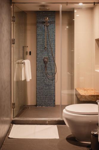 a bathroom with a shower and a toilet at RakYim Siam - Sukhumvit 15 in Bangkok