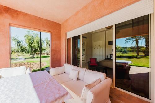 a living room with a couch and a large window at Dar Kamango - Marrakech Peaceful Retreat in Marrakesh
