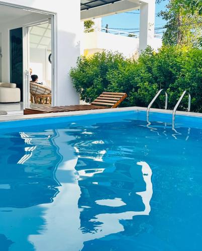 a swimming pool with blue water in front of a house at La Costa Hotel 15 Min from Airport,Free High-Speed WiFi, Spa Bath, Pool & Restaurant in Katunayaka