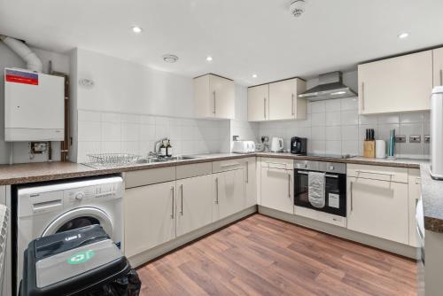 a kitchen with white cabinets and a dishwasher at 6 BR 4 Bath Central Worcester Sleeps 12 in Worcester