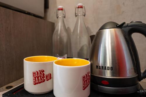 two cups of coffee sitting next to a tea kettle at GaasBaasCompany, Thamel, Kathmandu in Kathmandu