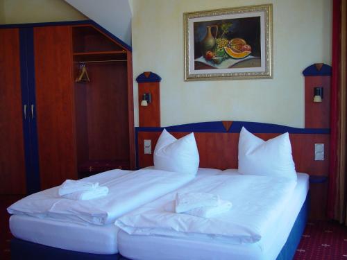 two beds in a hotel room with white pillows at Hotel Ostseeblick - direkt hinter den Dünen in Ostseebad Karlshagen