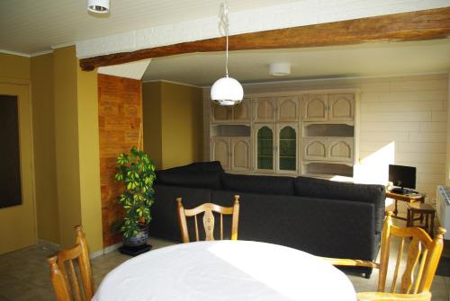 ein Wohnzimmer mit einer Couch und einem Tisch und Stühlen in der Unterkunft Gîte Horlitin in Amougies