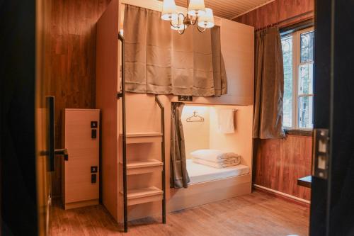 a small room with a bunk bed and a window at POSHPACKER - Chengdu Mix Hostel - Cicada Zen Yard in Chengdu