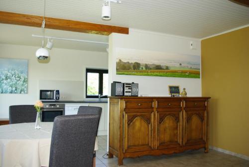 ein Esszimmer mit Tisch und eine Küche in der Unterkunft Gîte Horlitin in Amougies