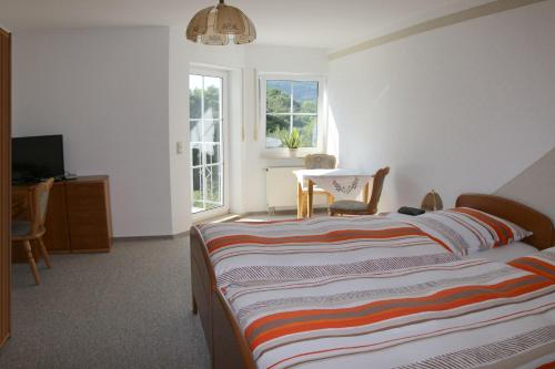 a bedroom with a bed and a table and a window at Pension Garni Haus Bismarckhöhe in Bad Ems