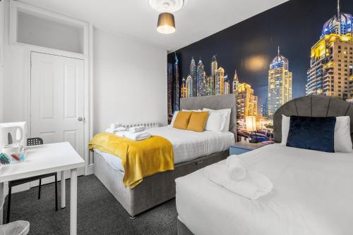 a bedroom with two beds and a city mural at 6 BR 4 Bath Central Worcester Sleeps 12 in Worcester