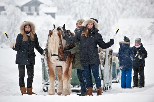 a group of people standing in the snow with a horse at Venabu Fjellhotell in Venabygd