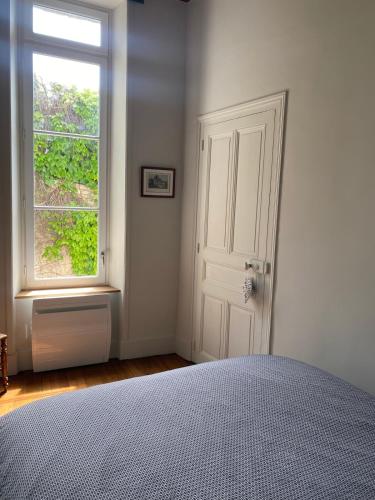 a white bedroom with a bed and a window at Maison Léopoldine 1 , Quartier Historique in Blois