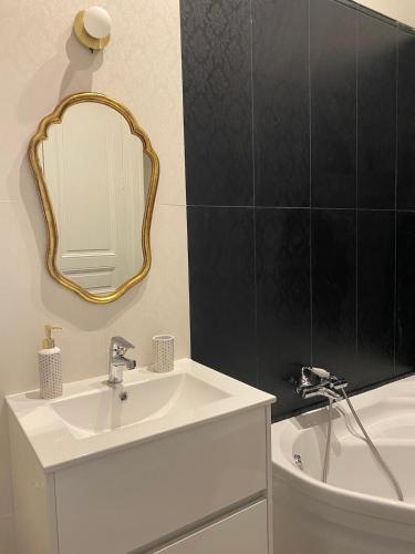 a bathroom with a sink and a mirror and a tub at Maison Léopoldine 1 , Quartier Historique in Blois