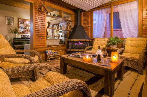 a living room with wicker chairs and a table with candles at Hotel Azaleia in Gramado