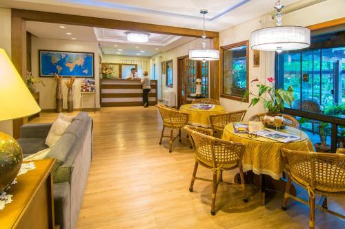 a living room with a couch and tables and chairs at Hotel Azaleia in Gramado