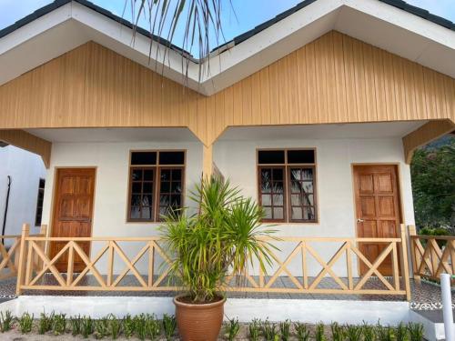 a small house with a wooden roof at Samudra Beach Chalet in Perhentian Islands