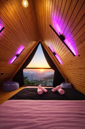 a bedroom with a bed with a large window at Uptown Batumi Yard & Jacuzzi in Batumi