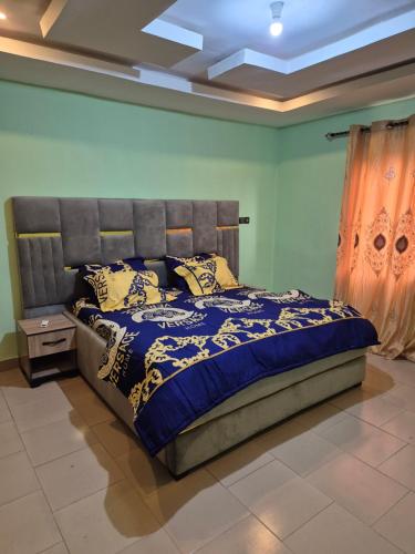 a bedroom with a bed with a blue comforter at G and E Guesthouse in Kumba