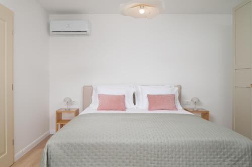 a bedroom with a large bed with pink pillows at Casa Sorelle secluded villa with breathtaking pool in Seline