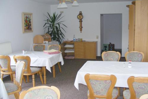 a room with two tables and chairs and a clock at Pension Garni Haus Bismarckhöhe in Bad Ems