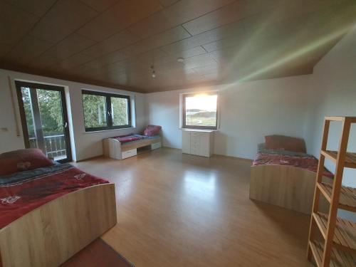 a large room with two beds and a wooden floor at Pension Heller in Odelzhausen