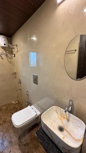 a bathroom with a sink and a toilet and a mirror at Nisarg Forever Resort in Jāmb